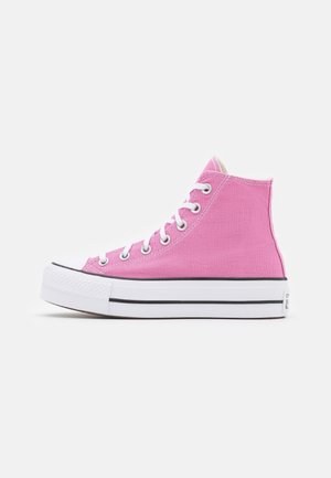 Roze hoge canvas sneaker met witte rubberen zool, witte veters, zilveren oogjes en zwart gestreept detail op een effen achtergrond.