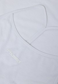 Canotta sportiva bianca con un motivo a rete testurizzato, dotata di spalline sottili e logo "hummel" ricamato.