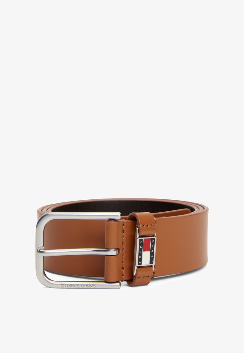 Brun skinnbelte med en sølvfarget metallspenne. Har en logodetalj nær spennen, glatt tekstur og et klassisk design.