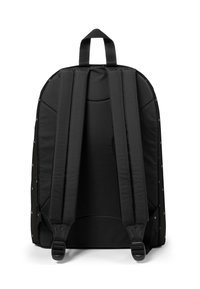 Czarny plecak z wyściełanymi paskami na ramiona, górnym uchwytem oraz metalowymi ćwiekami wzdłuż boków. Gładka, smukła faktura tkaniny, prostokątny kształt.