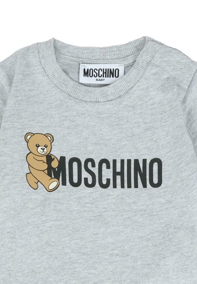 Felpa per bebè grigia chiara con bottoni a pressione sulla spalla, con un orsetto che abbraccia la "M" nel logo "MOSCHINO" sulla parte anteriore.