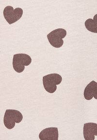 Cotton fabric in light beige with a repeated pattern of small, dark brown hearts. Texture appears soft with a smooth finish.