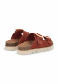 Sandales à glisser en suede marron avec deux nœuds surdimensionnés, semelle en liège et semelle extérieure en caoutchouc beige texturé présentant un design ondulé.