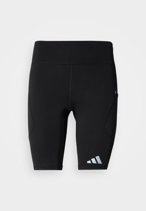 Černé atletické šortky z pružného materiálu. Mají přiléhavý střih, boční kapsy a reflexní logo na spodní části nohavice.
