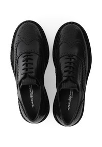 Zwarte leren brogue schoenen met gedetailleerde perforaties, een patroonzool en een gladde afwerking. Klassiek vetersluiting ontwerp zonder zichtbare hardware.