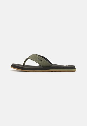 Green flip-flop sandal with a textured thong strap, a cushioned black footbed, and a rubber sole featuring a brown accent edge.