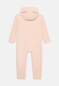 Mjuk rosa babyoverall med huva och små björnöron, långa ärmar och muddade ben, liggande platt som visar baksidan.