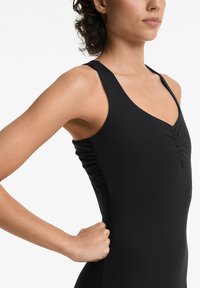 Zwarte zwemkleding met een V-halsontwerp. Het materiaal is soepel en heeft een gathering bij de buste en aan de zijkanten. De schouderbanden zijn breed en stevig.