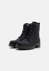 Bottes d'ankle noires avec un dessus en tissu texturé, bout rond et design à lacets. Comprend des œillets en argent et une semelle épaisse à motifs.