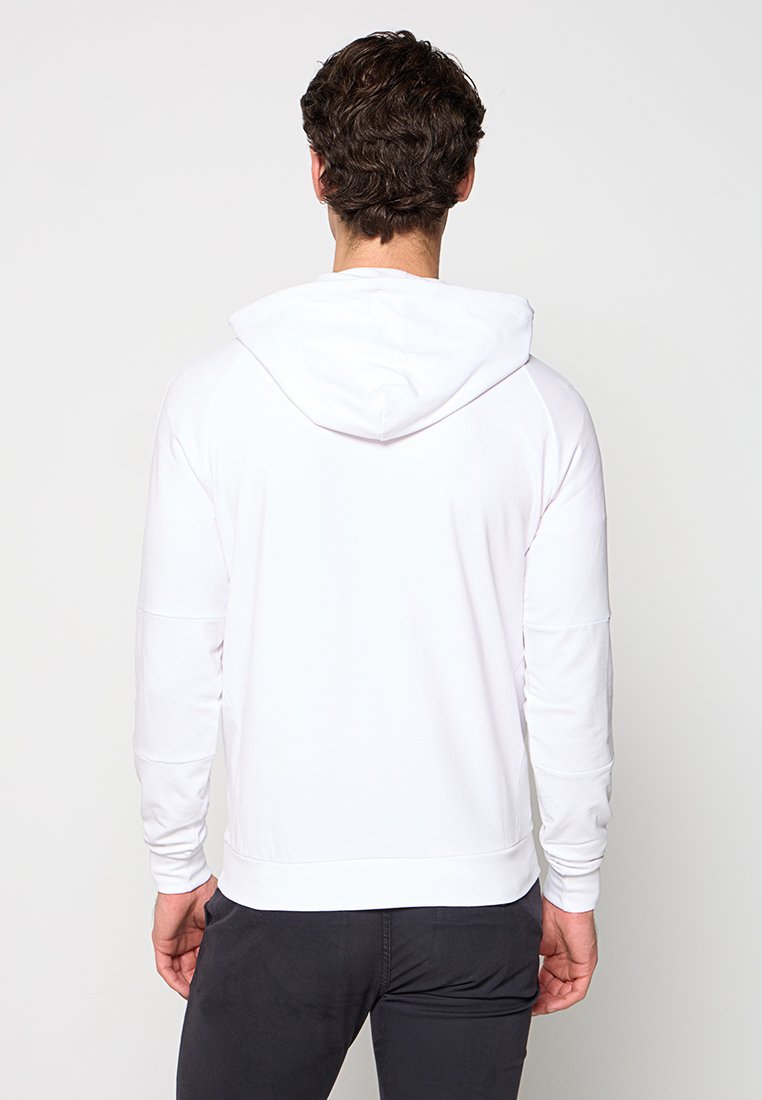 Sudadera blanca con un corte relajado, con capucha ajustable, puños de canalé y una textura suave. Sin logotipos ni patrones visibles.