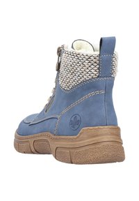 Niebieski skórzany botek za kostkę z teksturowanym kołnierzem z dzianiny, kontrastującą brązową gumową podeszwą i zamkiem błyskawicznym z boku. Logo wypukłe po boku.