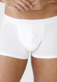 Boxer in cotone bianco con vita elastica. Texture liscia, design aderente e cuciture minime.