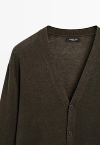 Dark green cardigan made of knitted fabric, featuring a V-neckline, long sleeves, and black buttons along the front placket.