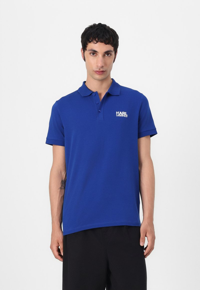 Blauwe polo gemaakt van katoen met een kraag, korte mouwen en een wit "KARL LAGERFELD" logo op de linkerborst. Minimalistisch ontwerp.