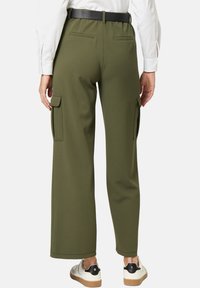 Olivegrüne, weit geschnittene Cargo-Hosen mit hinteren Taschen und seitlichen Cargo-Taschen. Weicher Stoff und ein elastischer Bund, kombiniert mit einem schwarzen Gürtel.