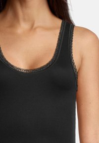 Black tank top with a lace-trimmed neckline. Made of smooth fabric and featuring wide straps for support.