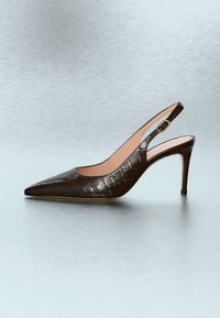 Chaussure à talon haut en cuir marron avec bride arrière, bout pointu et texture crocodile sur un fond clair uni.