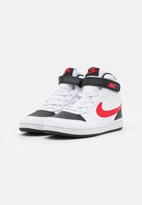 Tênis de cano alto brancos com detalhes pretos e o swoosh vermelho da Nike. Feitos de couro e malha, apresentam bico perfurado, cadarços e faixa de tornozelo.