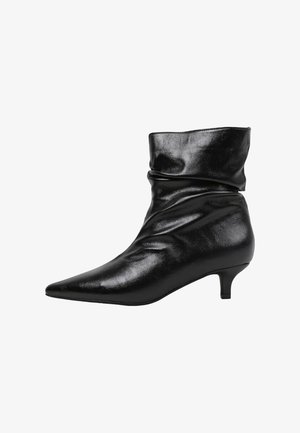 Botte cheville en cuir noir avec un design froncé, un bout pointu, et un talon modeste. La surface est brillante avec une texture lisse.