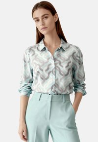 Light blue long-sleeve shirt with a patterned design in soft gray and white waves, featuring a classic collar and button front.