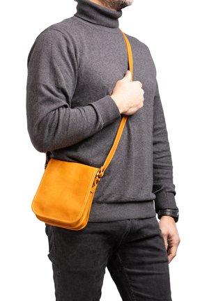 Borsa a tracolla in pelle di un vivace arancione, forma rettangolare con texture liscia. Presenta una lunga tracolla regolabile e dettagli di cucitura.