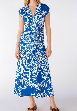 Blå og hvid blomsterprint maxi-kjole med V-udskæring, kap-sleeves og detalje med knude ved taljen. Let stof, flydende design med en glat tekstur.