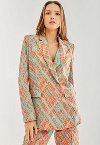 Colorful plaid blazer in orange, teal, and pink. Features double-breasted buttons, notched lapels, and side pockets. Smooth texture.