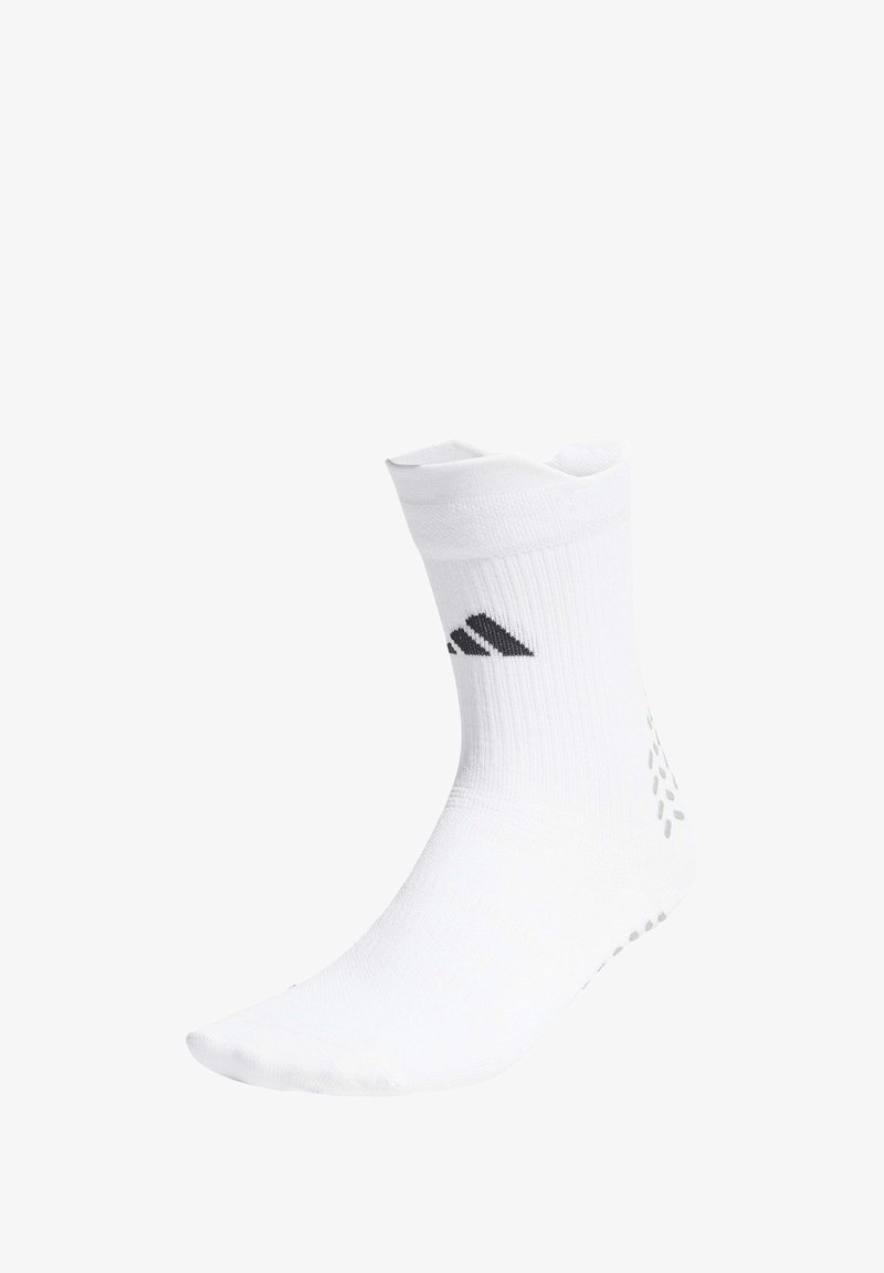 Calcetín blanco hasta el tobillo con el logo negro de Adidas en el cuff acanalado y puntos antideslizantes grises en el talón y la suela.