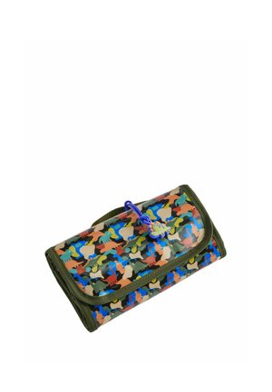 Cartera rectangular plegada con ribete verde oscuro y patrón de camuflaje de dinosaurios colorido, asegurada con una banda elástica azul y un colgante de dinosaurio.