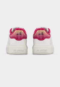 Ζευγάρι λευκών sneakers Love Moschino με ροζ λεπτομέρειες στη φτέρνα και ανάγλυφο το όνομα της μάρκας στις σόλες, εμφανιζόμενα από πίσω.