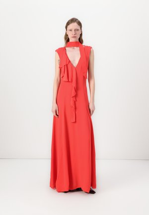Robe maxi rouge avec un décolleté en V profond, détails à volants au niveau du col et sur le devant, fabriquée en tissu léger, texture lisse.