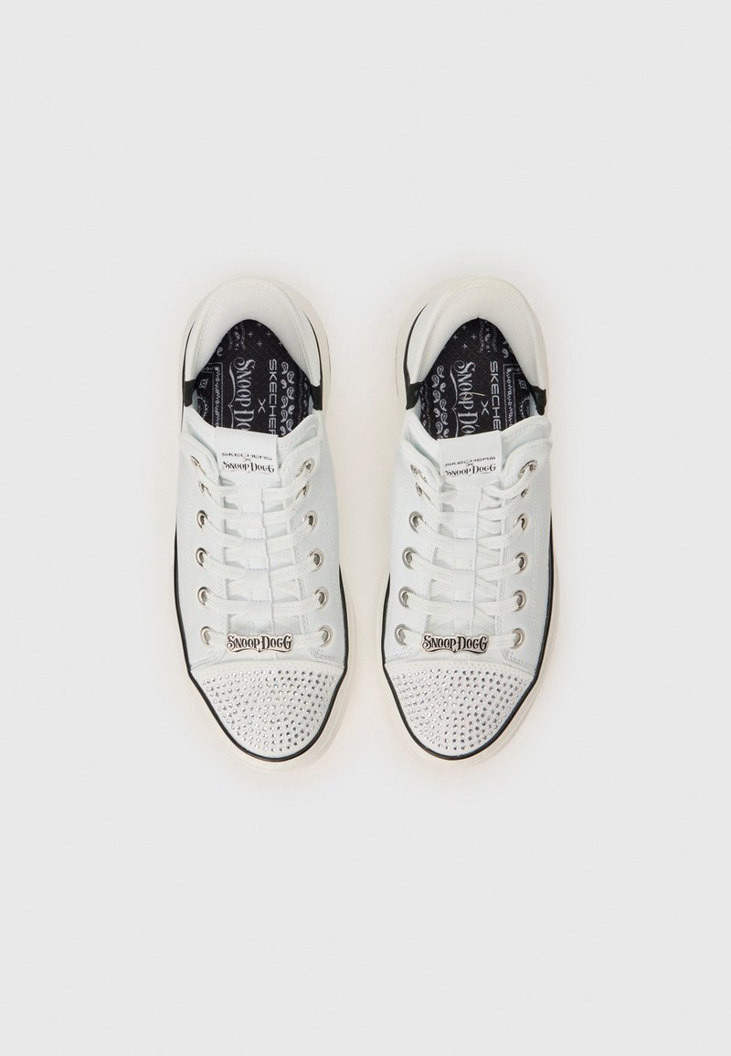 Sneaker bianche con finitura lucida, design con lacci, punta rinforzata con borchie argentate e branding di Snoop Dogg sui lati e sulle sole interne.