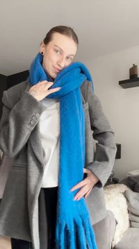 Sinine villane sall fringi detailidega, juhuslikult kaela ümber, kombinatsioonis halli mantli ja lihtsa valge toppiga.