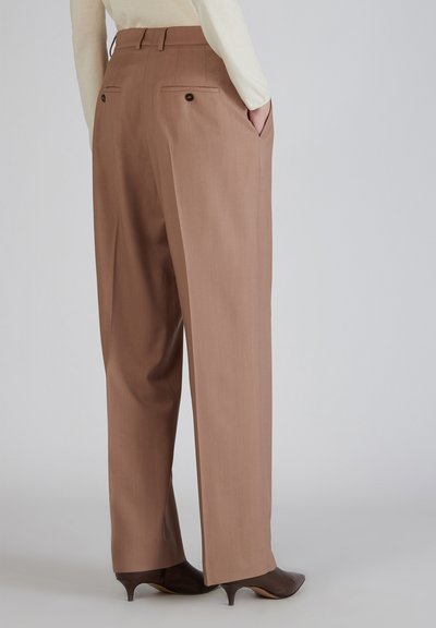 Bruine op maat gemaakte broek met een hoge taille, zijzakken en twee achterzakken met knoopsluitingen, gemaakt van gladde, lichtgewicht stof.