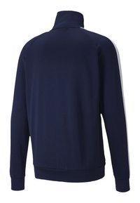 Námořnická modrá sportovní bunda, vysoký límec, dlouhé rukávy, elastické manžety, s bílými bočními pruhy, hladká tkanina, přiléhavý střih.