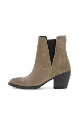 Stivale alla caviglia in suede marrone con tacco sollevato, pannelli laterali elastici, punta affusolata e cuciture decorative bianche lungo le cuciture.