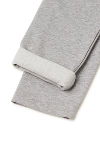 Šedé tepláky mají ohrnutý lem u kotníku, vyrobené z měkké bavlněné tkaniny s hladkou texturou a jemným melírováním.