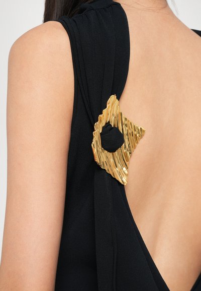 Vestido preto com um elegante detalhe em hardware dourado texturizado em forma triangular no ombro, destacando um design com recorte.