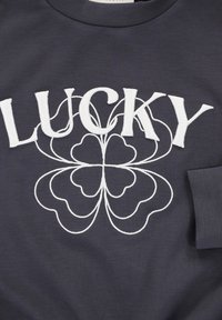 Donkergrijs katoenen T-shirt met een opvallende witte borduursel van het woord "LUCKY" en een decoratief klaverachtig ontwerp eronder.