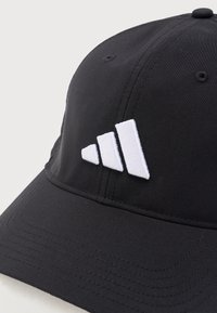 Μαύρο καπέλο μπέιζμπολ με λευκό λογότυπο τριών ρίγων κεντημένο στο μπροστινό πάνελ, καμπυλωτό γείσο και ραμμένες οπές αερισμού.