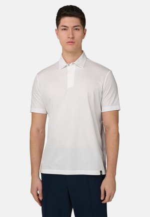 Polo blanc à manches courtes, col classique et patte de boutonnage à moitié ouverte. Tissu lisse avec une coupe décontractée et un design minimaliste.