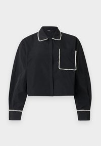 Camiseta negra de manga larga y corte corto, con bolsillo delantero, cuello y puños adornados con cuentas blancas en forma de perla.
