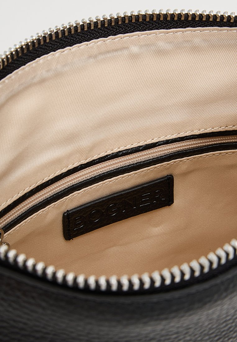 Schwarze Lederhandtasche mit einem glatten, beige-farbenen Innenfutter. Verfügt über eine Reißverschlusstasche und ein gebrandetes Lederschild. Silberne Reißverschlussdetails.