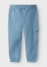 Pantalons de survêtement en coton bleu avec une coupe décontractée, présentant des poignets côtelés et une poche cargo sur le côté. Texture lisse, design simple.