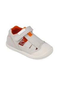 Zapato gris con acentos naranjas, parte superior de tela texturizada, tiras de velcro y suela de goma. Diseñado para comodidad y transpirabilidad.