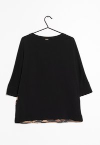 Haut à manches longues noir avec un col rond ; présente une accentuations en imprimé léopard le long de l'ourlet et un tissu doux et texturé.
