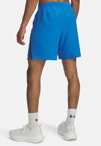 Blå sportshorts med dragsko i midjan, sidofickor och en lätt struktur. I kombination med vita sneakers och ankelsockor.