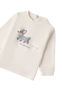 Camicetta a maniche lunghe di colore crema realizzata in tessuto morbido, con un cane cartone animato grigio che indossa una camicia a righe blu e testo sotto l'immagine.