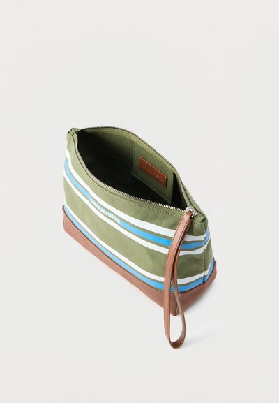 Pochette zippée vert olive avec des rayures blanches et bleues, base marron, bracelet en cuir et petite étiquette intérieure avec le nom de la marque.