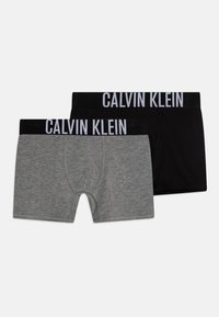 Grijze en zwarte boxershorts met een brede zwarte tailleband waarop "CALVIN KLEIN" in witte letters is gedrukt. Gemaakt van zachte, rekbare stof.